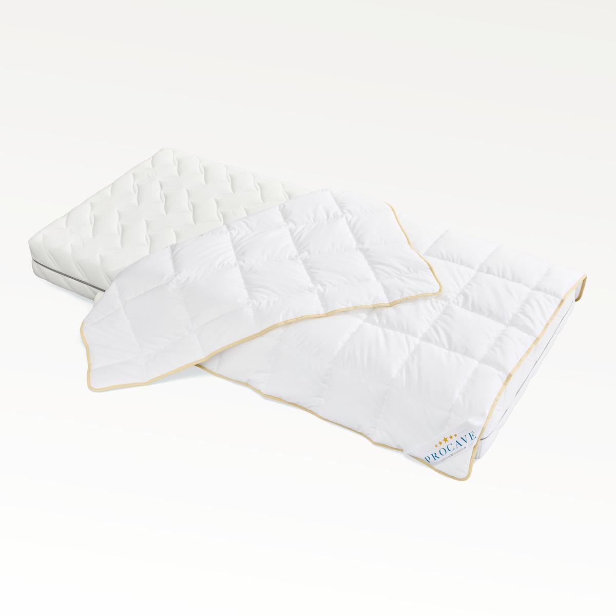 PROCAVE Tencel Qualitäts-Ganzjahresdecke aufgeklappt auf Matratze, weißes Obermaterial mit goldenem Einfassband — Produktfreisteller Ganzjahresdecke mit Tencel-Füllung